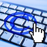 Copyright symbol projected on keyboard with digitized clicking finger